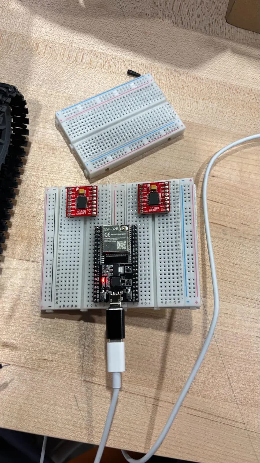 The drive electronics on a breadboard: an ESP32 dev board wired to two red dual-channel motor-driver boards.